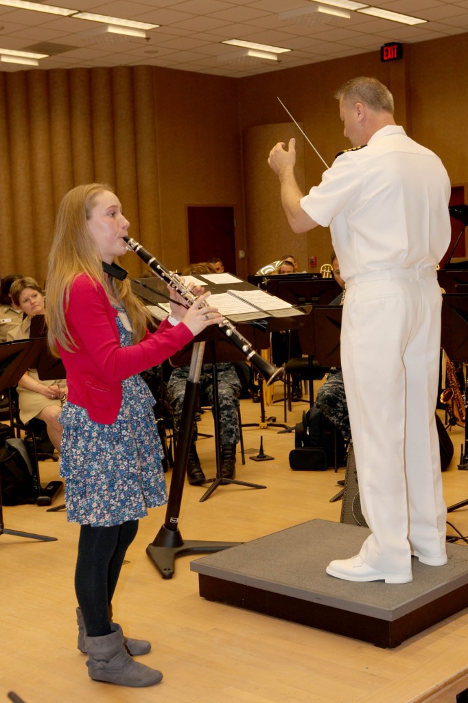 Arianna Beyer, left, winner of the Navy Band High School Concerto Competition, performs her solo during the Navy Concert Band rehearsal for the Annual High School Concerto Competition Concert. Directing is Navy Band Commanding Officer Captain Brian Walden. U.S. Navy Photo 130510-N-HG258-099