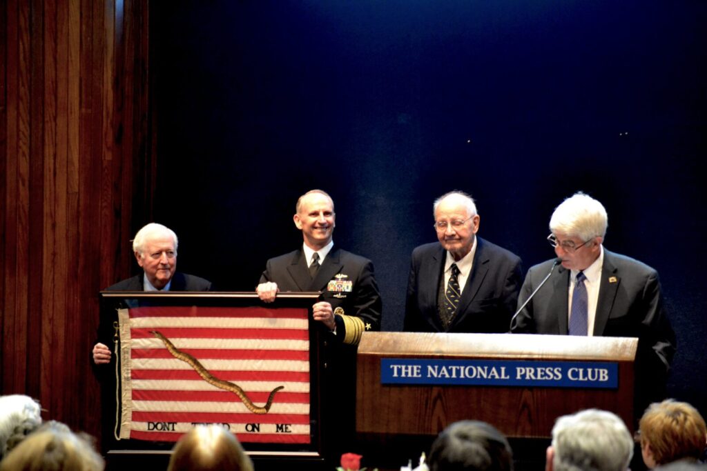NHF Chairman Bruce DeMars, USN (Ret.) and Ambassador Middendorf present Greenert with an original 1975 Navy Jack.