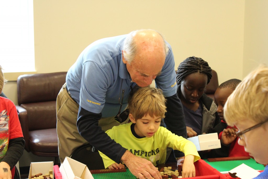 A Kalmar Nyckel volunteer works with a participant as he builds Battleship Wisconsin. (NHF Photo/Matthew Eng/Released)